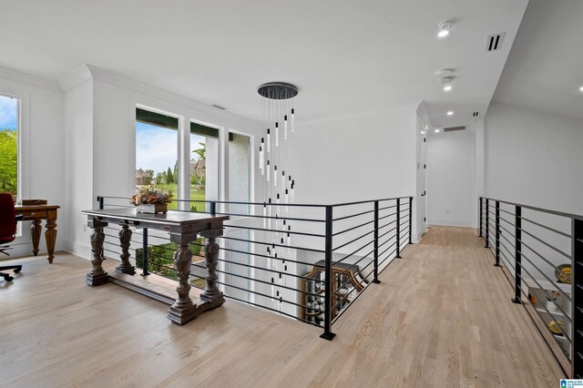 hallway featuring light wood finished floors, an upstairs landing, baseboards, and recessed lighting