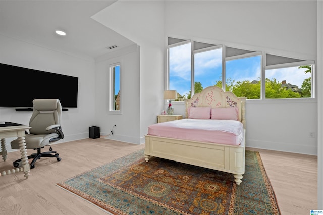 bedroom featuring wood finished floors, baseboards, an office area, and recessed lighting
