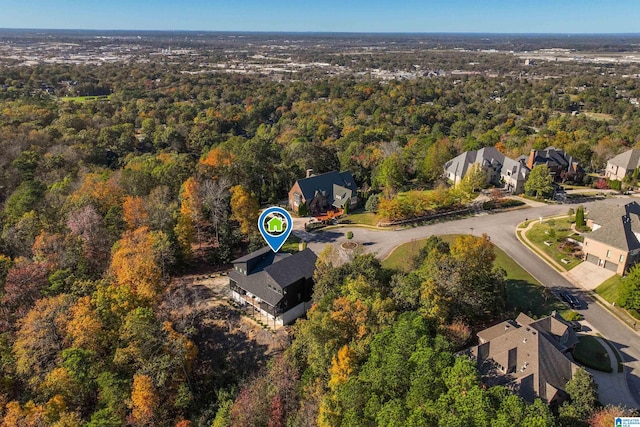 view of property location featuring a heavily wooded area and nearby suburban area