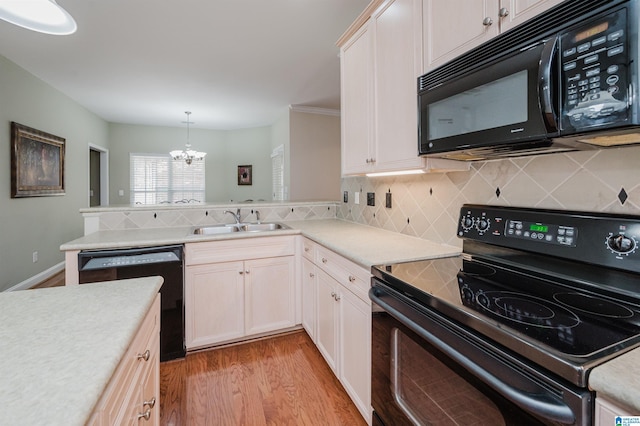 124 Blackstone Ct, Chelsea, AL 35043 - kitchen featuring a sink, black appliances, light wood finished floors, a peninsula, and a notable chandelier