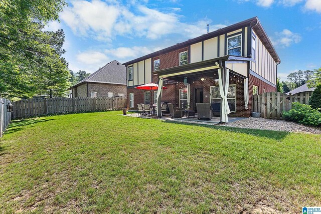 rear view of property with a patio, a fenced backyard, brick siding, board and batten siding, and a yard