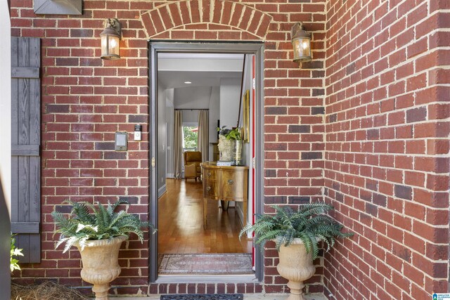 doorway to property featuring brick siding