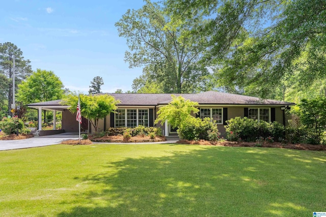 ranch-style house featuring a front lawn, driveway, and an attached carport