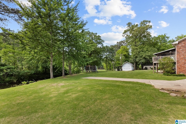 1700 Kestwick Dr, Hoover, AL 35226 - view of yard featuring an outdoor structure, a trampoline, and a detached garage