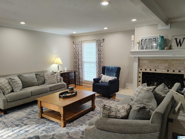 living area featuring ornamental molding, wood finished floors, recessed lighting, a textured ceiling, and a tiled fireplace