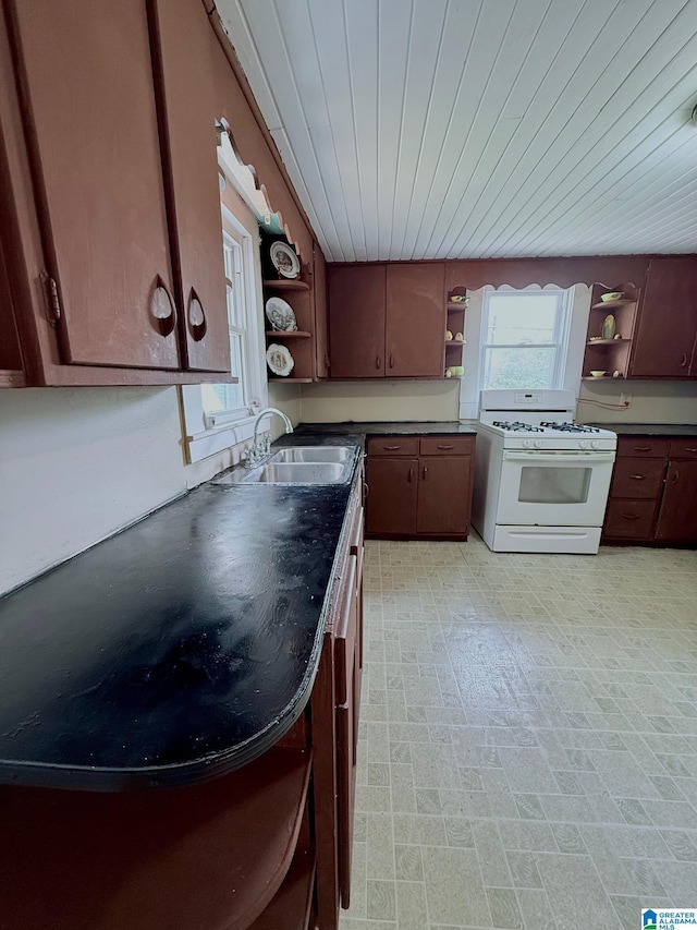 103 Thatcher St, Piedmont, AL 36272 - kitchen featuring dark countertops, open shelves, white range with gas cooktop, and a sink