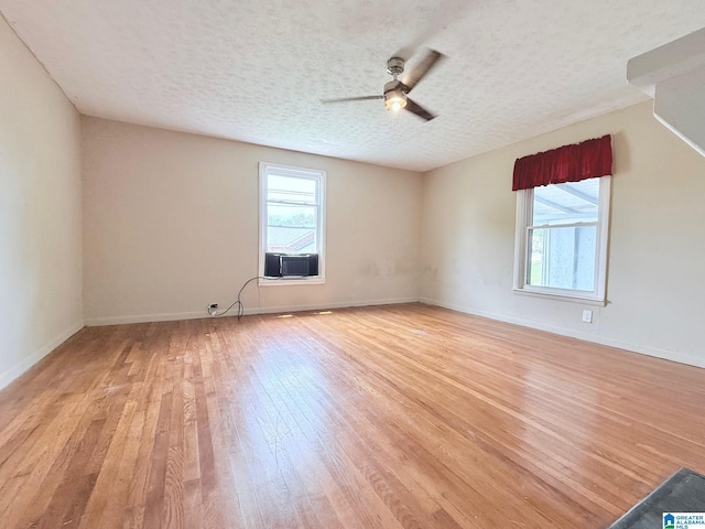 103 Thatcher St, Piedmont, AL 36272 - spare room with baseboards, ceiling fan, a textured ceiling, cooling unit, and light wood-style flooring