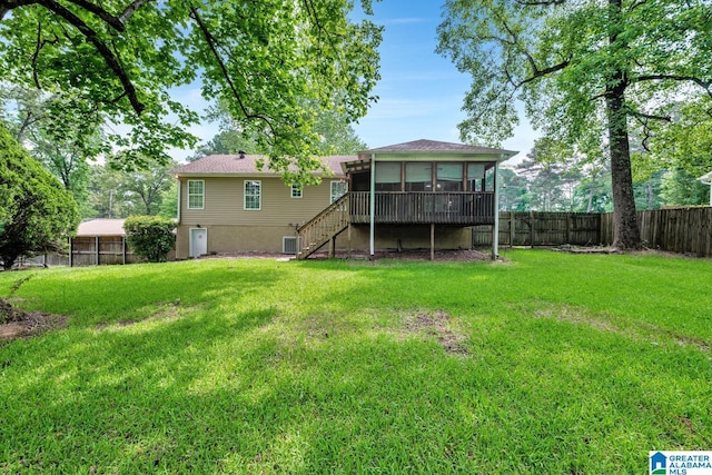 back of property featuring a fenced backyard, a yard, stairs, and a sunroom