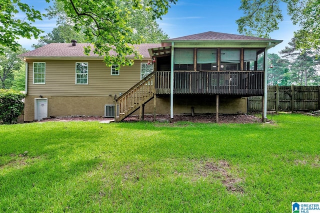rear view of property featuring fence, a lawn, stairs, and a sunroom