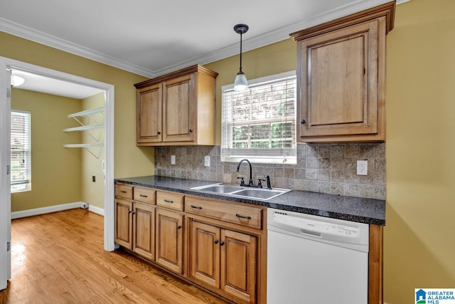 kitchen featuring backsplash, white dishwasher, dark countertops, and a sink