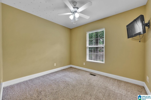 spare room featuring carpet flooring, a ceiling fan, baseboards, and visible vents