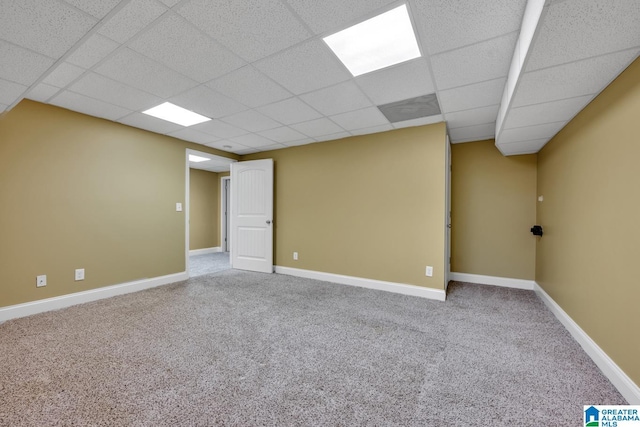 finished basement with baseboards, carpet, and a paneled ceiling