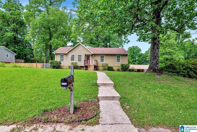 ranch-style house featuring fence and a front yard