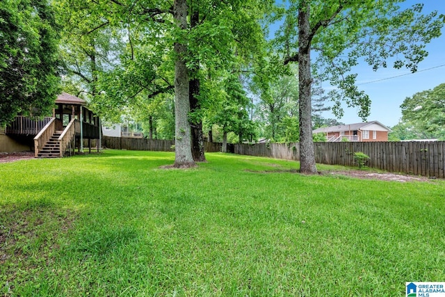 view of yard featuring stairway, a deck, and a fenced backyard