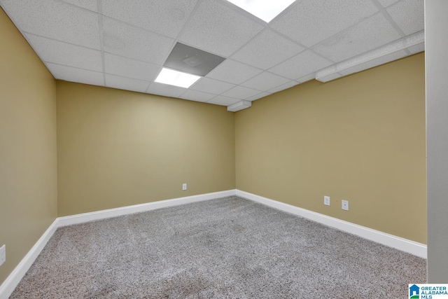 unfurnished room with baseboards, carpet flooring, and a drop ceiling