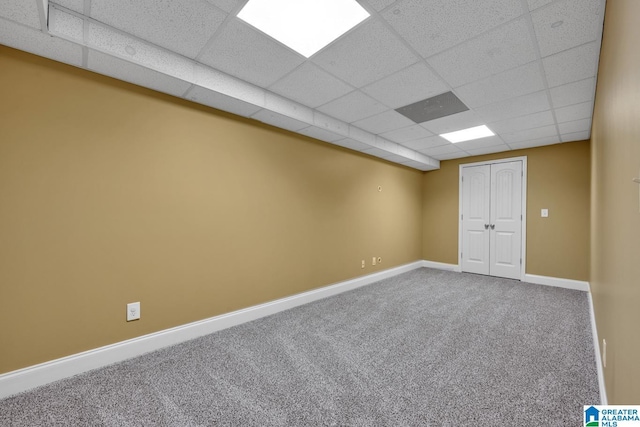 finished basement featuring carpet flooring, baseboards, and a drop ceiling