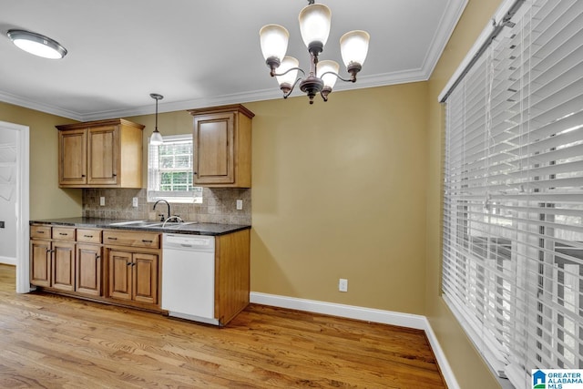 kitchen with white dishwasher, dark countertops, an inviting chandelier, light wood-style floors, and decorative backsplash