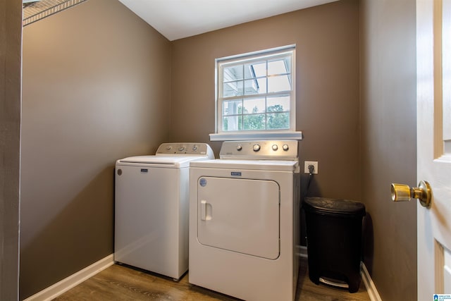 laundry area with baseboards, laundry area, wood finished floors, and washer and clothes dryer