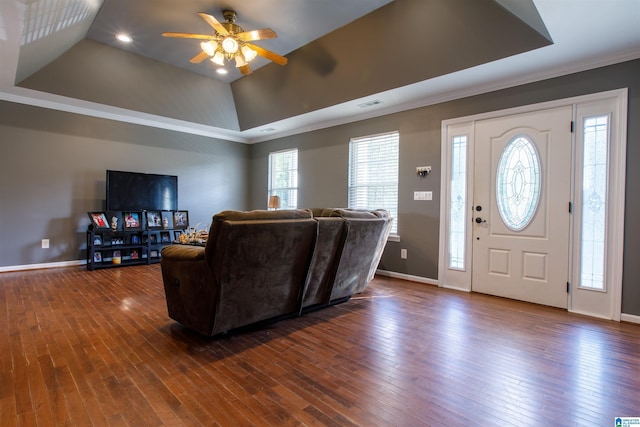 living room featuring crown molding, a ceiling fan, dark wood finished floors, and a tray ceiling