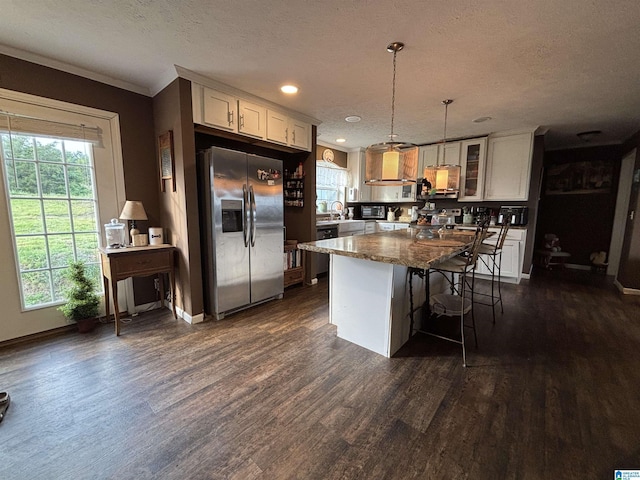 1525 Marvin Adcock Rd, Hayden, AL 35079 - kitchen featuring stainless steel refrigerator with ice dispenser, white cabinetry, dark wood-style flooring, a kitchen bar, and ornamental molding