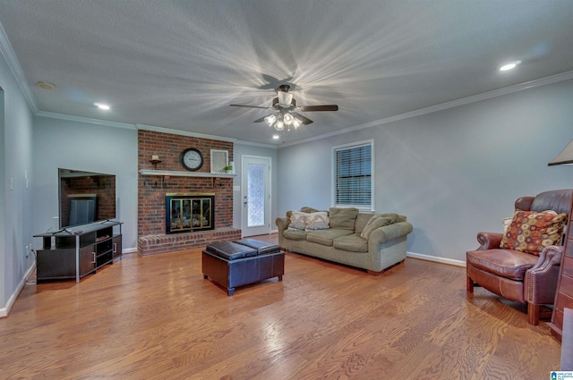 living area with a brick fireplace, a ceiling fan, baseboards, recessed lighting, and wood finished floors