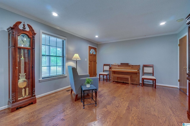 sitting room featuring recessed lighting, baseboards, ornamental molding, and wood finished floors