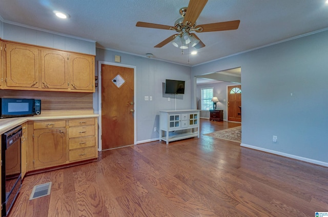 kitchen featuring visible vents, wood finished floors, ceiling fan, light countertops, and black appliances
