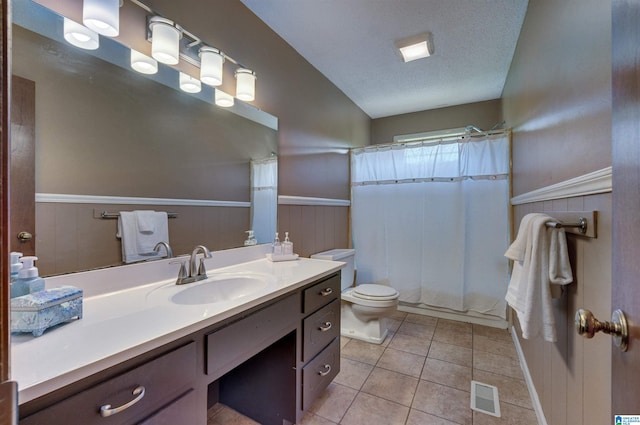 bathroom featuring visible vents, tile patterned flooring, wainscoting, vanity, and toilet