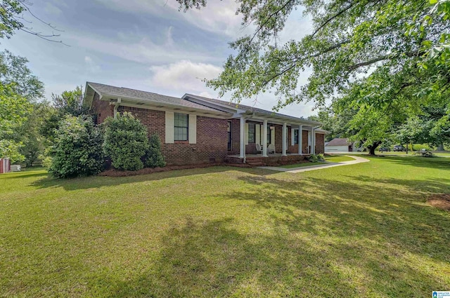 ranch-style house featuring covered porch, a front lawn, and brick siding