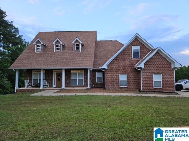 view of front facade featuring brick siding and a front yard