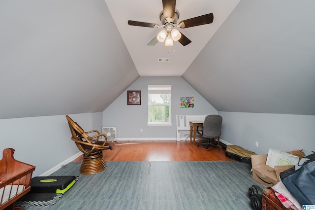 office area with a ceiling fan, visible vents, vaulted ceiling, wood finished floors, and baseboards