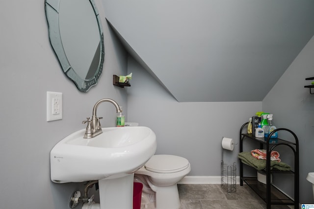 half bathroom with toilet, baseboards, a sink, and lofted ceiling