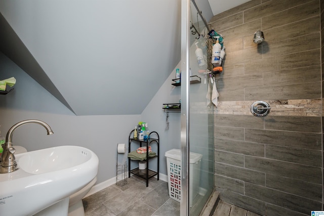 full bath featuring a sink, tile patterned floors, baseboards, a shower stall, and lofted ceiling