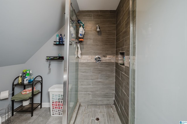 bathroom featuring vaulted ceiling and a shower stall