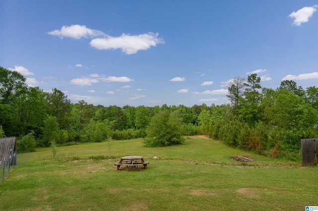 view of yard featuring fence and a wooded view