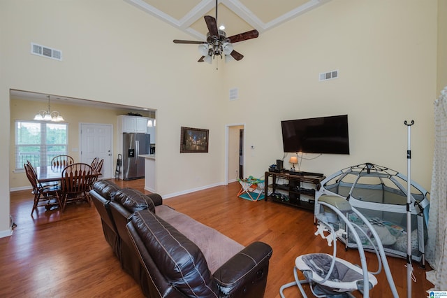 living room featuring visible vents, baseboards, ceiling fan with notable chandelier, and wood finished floors