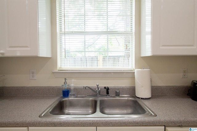 kitchen featuring a sink and white cabinetry