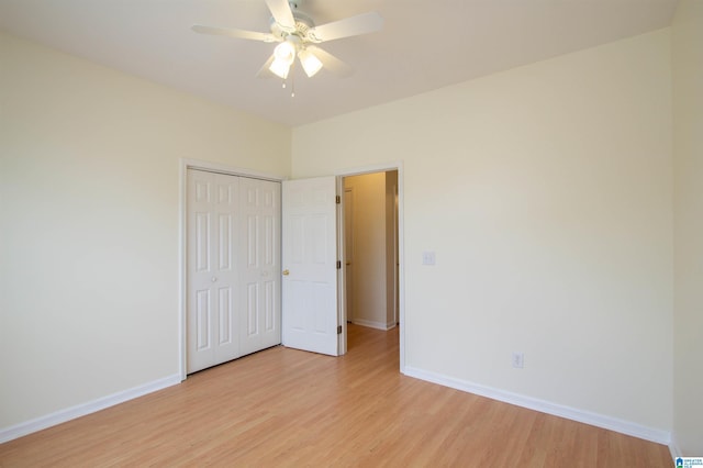 unfurnished bedroom featuring light wood-style floors, baseboards, ceiling fan, and a closet