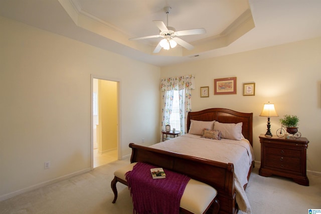 bedroom featuring crown molding, baseboards, light colored carpet, and a raised ceiling