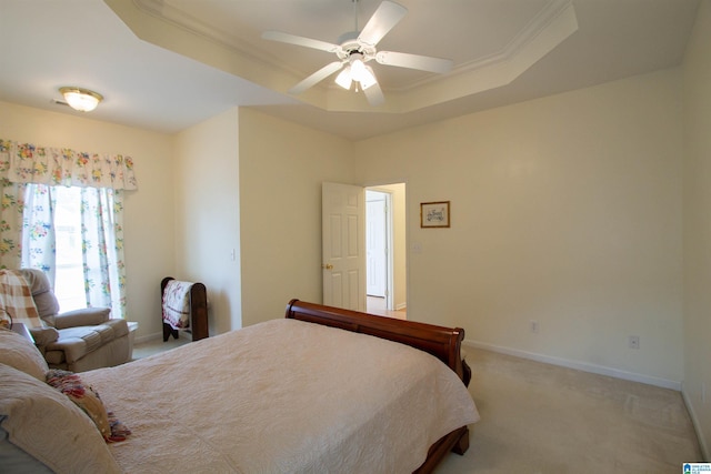 bedroom with light colored carpet, a raised ceiling, ceiling fan, and baseboards