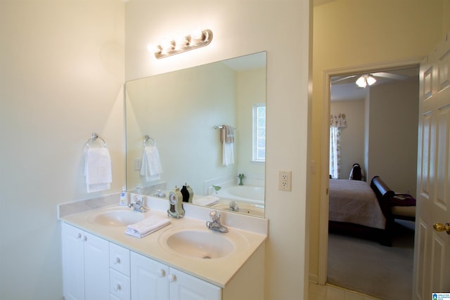 ensuite bathroom with double vanity, a sink, a bath, and ensuite bath