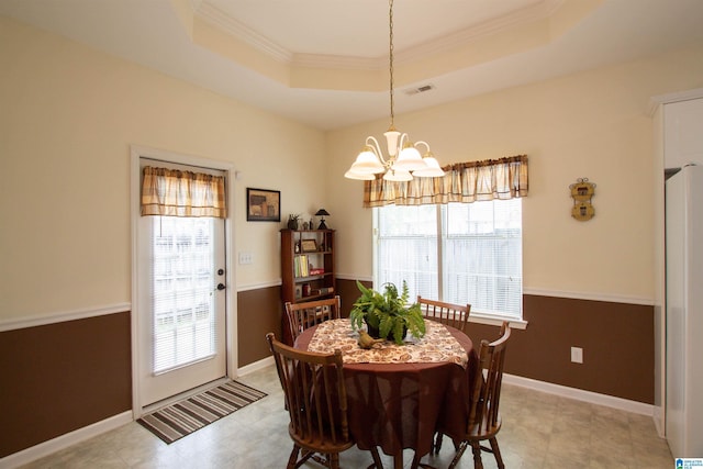 dining room with visible vents, plenty of natural light, an inviting chandelier, and a raised ceiling