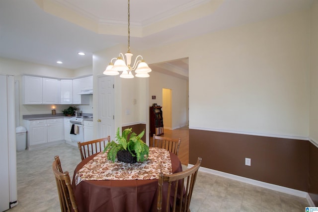 dining area featuring ornamental molding, baseboards, recessed lighting, a raised ceiling, and a chandelier