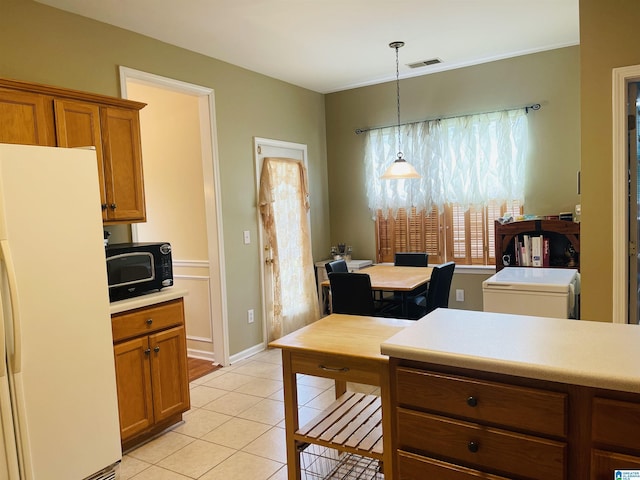 196 King James Ct, Alabaster, AL 35007 - kitchen with freestanding refrigerator, black microwave, brown cabinets, and light tile patterned flooring