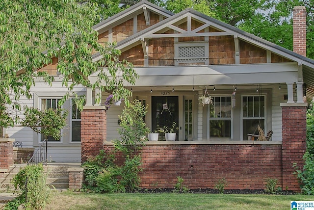 view of front of property featuring brick siding and a chimney