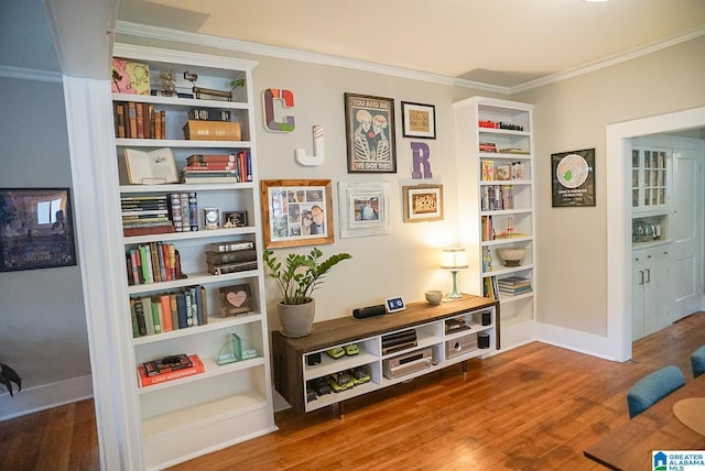 living area with crown molding, baseboards, and wood finished floors