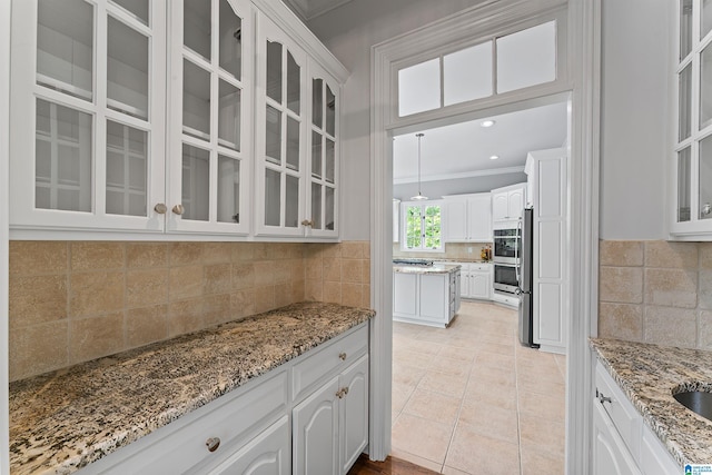 2074 Royal Fern Ln, Hoover, AL 35244 - kitchen featuring white cabinetry, light stone countertops, ornamental molding, and tasteful backsplash