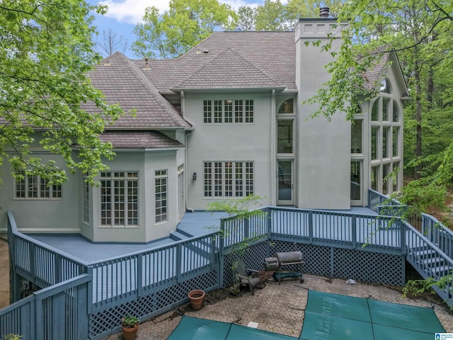 2074 Royal Fern Ln, Hoover, AL 35244 - rear view of property featuring a wooden deck, stucco siding, a chimney, and a tiled roof