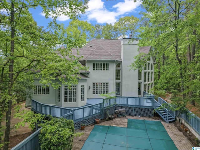 2074 Royal Fern Ln, Hoover, AL 35244 - rear view of house featuring a chimney, a fenced in pool, a wooden deck, and stucco siding