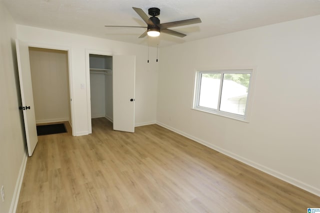 unfurnished bedroom with a closet, a ceiling fan, light wood finished floors, and baseboards